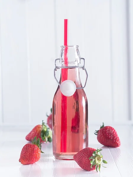 Sumo de morango em uma garrafa com uma palha — Fotografia de Stock
