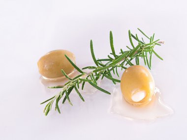 Bir dal biberiye ile yeşil zeytin