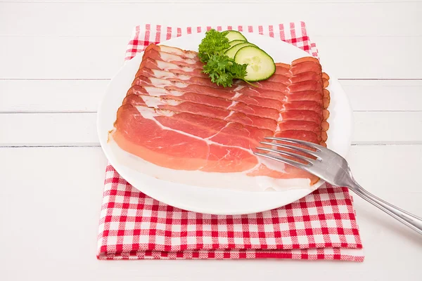 Ham in discs lies cut on a plate — Stock Photo, Image