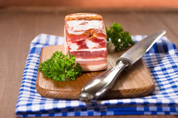 Gerookt spek op een houten plank — Stockfoto