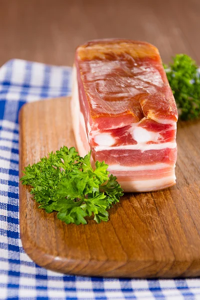 Smoked bacon on a wooden board — Stock Photo, Image