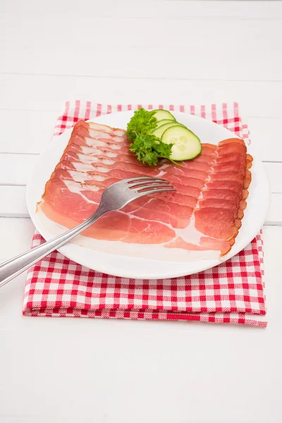 Ham in schijven ligt gesneden op een plaat — Stockfoto