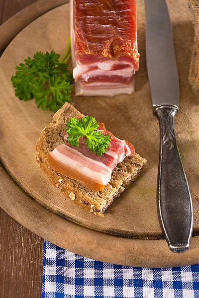 Gerookt spek op een houten plank — Stockfoto