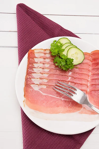 Ham in schijven ligt gesneden op een plaat — Stockfoto