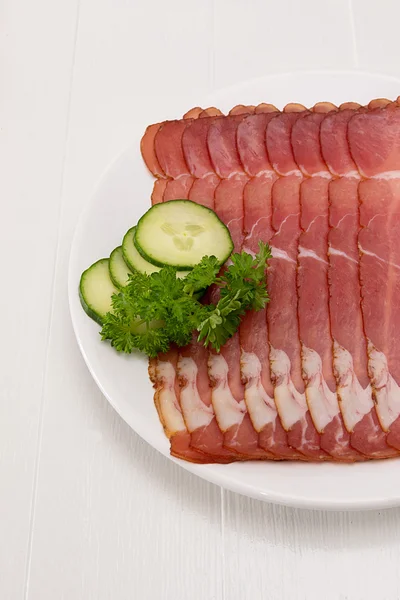 Ham in schijven ligt gesneden op een plaat — Stockfoto