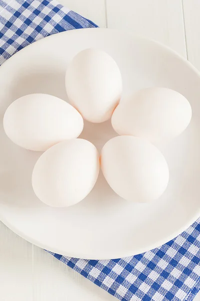 Os ovos crus estão em uma chapa — Fotografia de Stock
