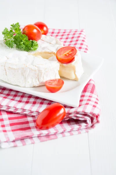 A round Camembert on a white plate