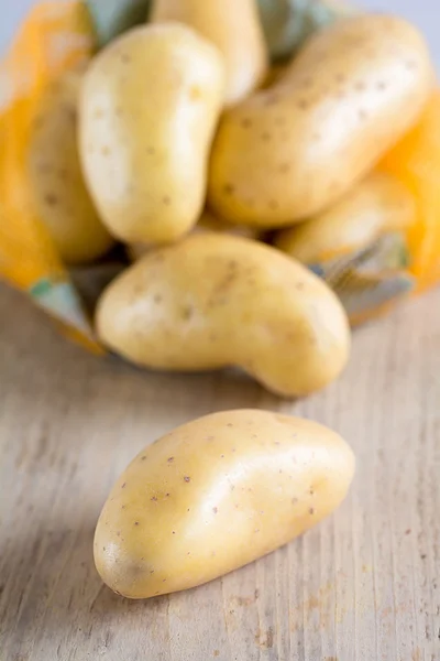 Raw potatoes lie on a board — Stock Photo, Image