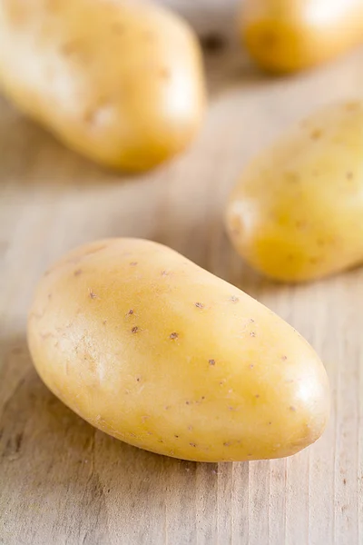 Raw potatoes lie on a board — Stock Photo, Image