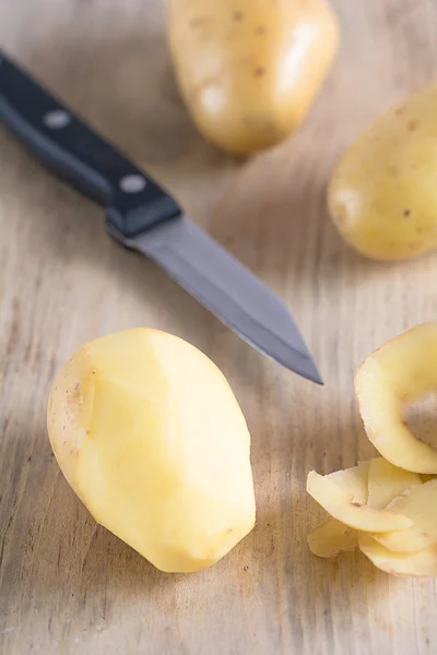 Las patatas crudas yacen sobre un tablero —  Fotos de Stock