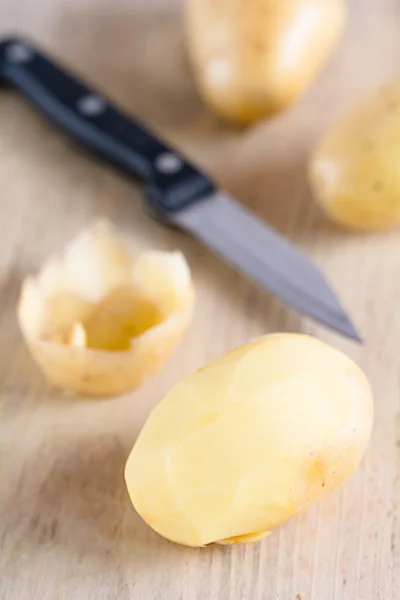 Las patatas crudas yacen sobre un tablero —  Fotos de Stock