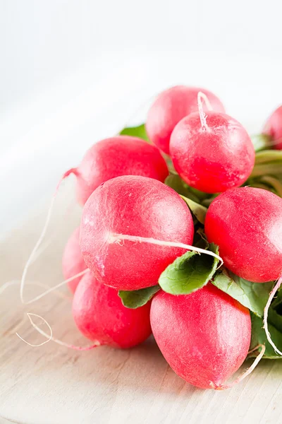 Een bundel radijs ligt op een bord — Stockfoto