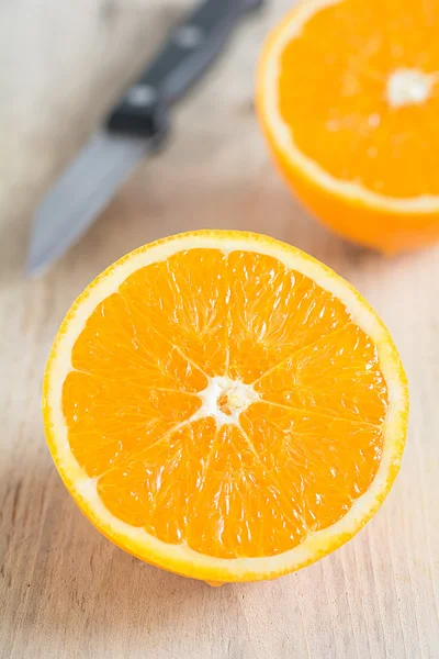 Порезанный апельсин лежит на доске — стоковое фото