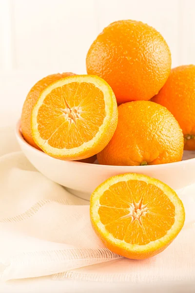 Апельсины лежат в фарфоровой чаше — стоковое фото