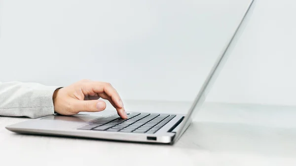 Zijaanzicht Van Slanke Zilveren Laptop Een Grijs Bureau Vrouwelijke Hand — Stockfoto