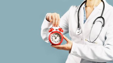 Doktorlar mavi arka planda kırmızı alarmlı saati tutuyorlar. Zaman çok önemli bir kurtarıcıdır. Tıbbi afiş. Uzayı kopyala Randevu ya da kontrol zamanı anımsatıcı.