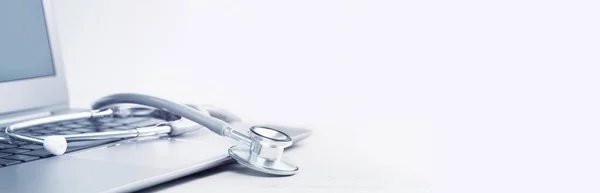 Dizüstü bilgisayarda steteskop. Virüs sezonu, salgın hastalık. Uzaktan ilaç ya da elkazanımcılık ve teletıp danışmanlık tavsiyesi. Uzayı kopyala Tıbbi ağ ya da bizimle bağlantı kurun