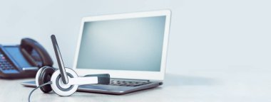 İş ve iletişim. Laptop ve vop telefonları ofiste. Giyin ya da online konferans yap. Bilgisayar masanın üstünde. IP telefonu, soğuk telefon. Ofis işi ya da öğrenme. Uzayı kopyala Pankart