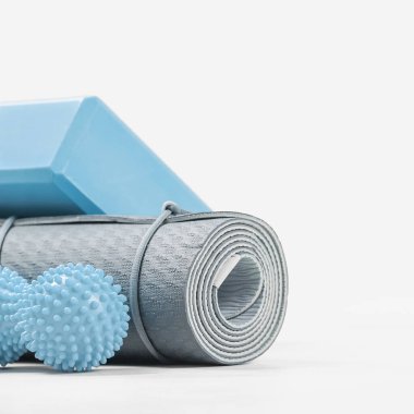 Yuvarlak mavi yoga minderi ve köpük bloğu veya tuğla, masaj topu. Kopya alanlı cinsiyet ayrımcılığı ve egzersiz konsepti aksesuarları. Aktif yaşam tarzı. Evde ya da spor salonunda, spor kulübü posterinde.