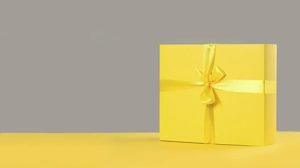 Caja de regalo amarilla sobre fondo gris o gris — Foto de Stock