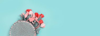 Pastel deniz mavisi üzerinde hasır bir çantada taze kırmızı laleler. Fotokopi odası, doğum günü hediyesi. Sevgililer Günü 8 Mart Kadın ya da Öğretmenler Günü Anneler Günü tebrik kartı ya da asgari afiş