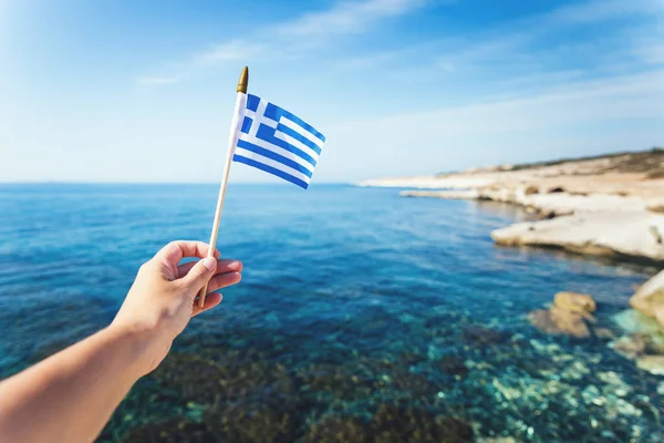 El ele tutuşan Yunan bayrağı deniz dalgaları üzerinde dalgalanıyor. Yunanistan 'a ya da Ulusal Gün' e git. Boşluğu kopyala