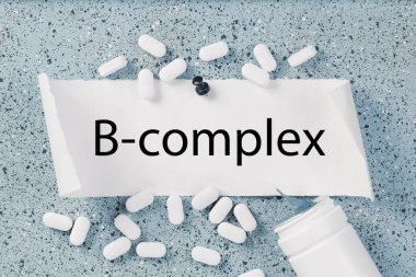 Beyaz kapsüllü B vitamini kompleksi metni ya da uyarı panosunda haplar. Tıp ve refah sağlığı