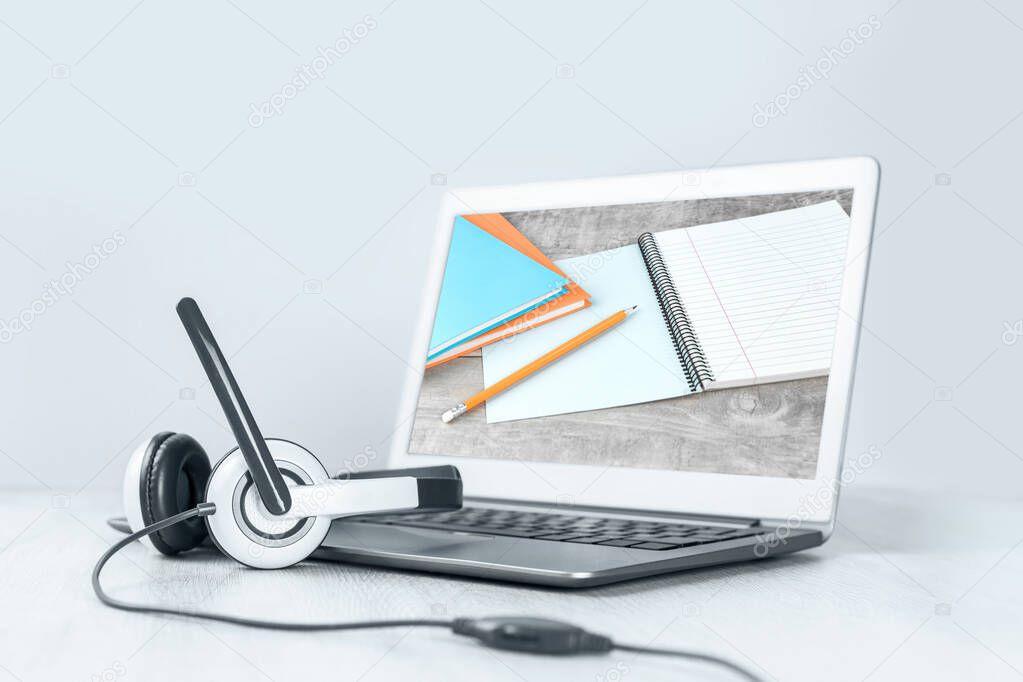 Laptop. screen with notebooks and headphones on white desk blue background banner. Distant learning or working from home, online courses or shopping minimal concept. workshop. Storytelling