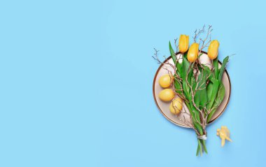 Sarı lale buketi, Paskalya yumurtası ve metal tepside goden dekoru dalları olan tavşan. Mavi arka planda düz yatıyordu. Mutlu Paskalya soyut tebrik kartları. Boşluğu kopyala