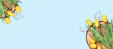 Sarı lale buketi ve metal tepside altın desenli paskalya yumurtaları. Mavi arka planda düz yatıyordu. Mutlu Paskalyalar. Soyut tebrik kartı ya da afiş.