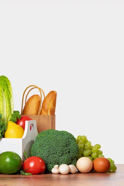 Delivery of grocery. Bread. Box with fresh fruit and vegetables bright green produce. Eco friendly responsible lifestyle and shopping. Healthy eating, zero waste concept. Copy space. Donation.