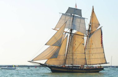 CLEVELAND, OH - JULY 7: The topsail schooner Pride of Baltimore II sails into the evening sun in the Parade of Ships that began the 2010 Tall Ships Festival (July 7-12) on July 7, 2010 in Cleveland, Ohio clipart