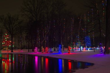 Kuzeydoğu Ohio şehir parkındaki Noel ışıklandırması küçük bir gölün cam sularına yansıyor..
