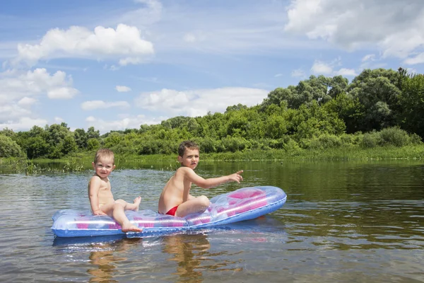 En été sur la rivière sur un matelas gonflable drôle littl — Photo