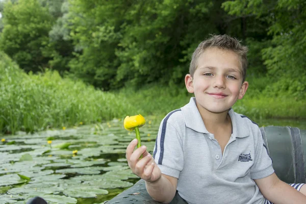 En el verano en el río un niño sentado en un bote de goma — Foto de Stock