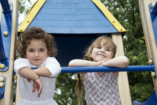 Im Sommer zwei kleine Mädchen auf dem Spielplatz spielen. — Stockfoto