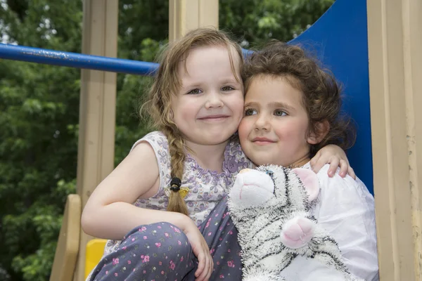 En été, deux petites filles jouent sur l'aire de jeux . — Photo