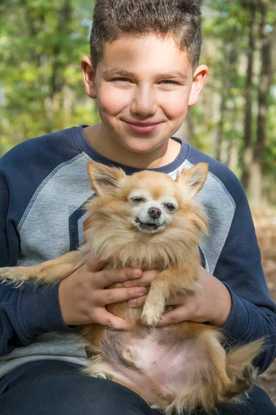 Létě Lese Drží Šťastný Chlapec Náručí Malého Červeného Psa — Stock fotografie