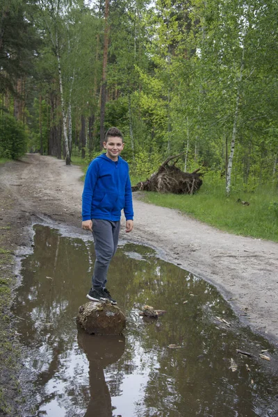 Létě Lese Během Dne Uprostřed Louže Stojí Chlapec Pařezu — Stock fotografie