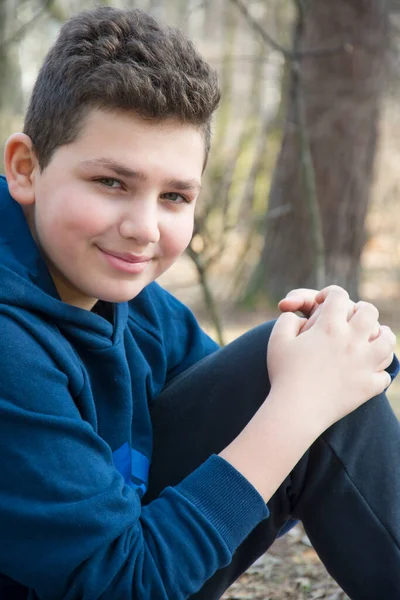 Een Zonnige Lentedag Zit Een Gelukkige Jongen Het Bos Close Stockfoto