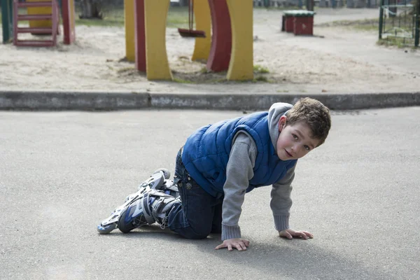 Spring boy rollerblading dan jatuh di jalan . — Stok Foto