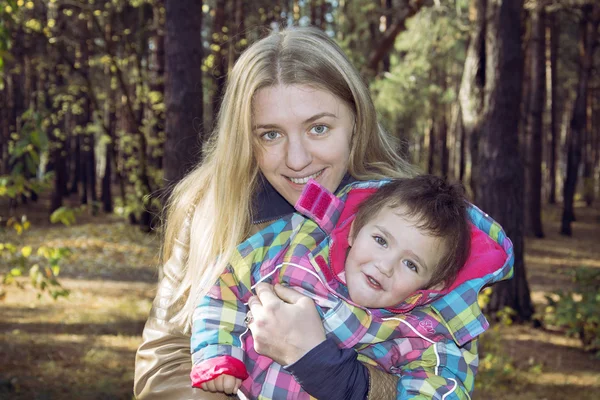 Mamma med en dotter i höst skog. — Stockfoto