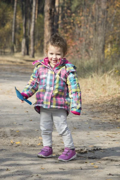 Bambina che gioca con una pala scavare il terreno in autu — Foto Stock