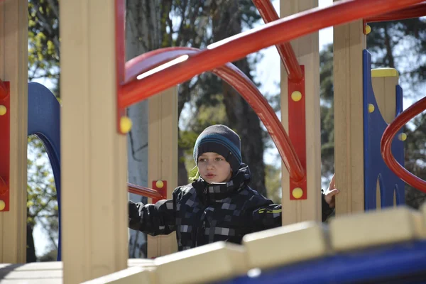 Menino da primavera brincando no playground . — Fotografia de Stock