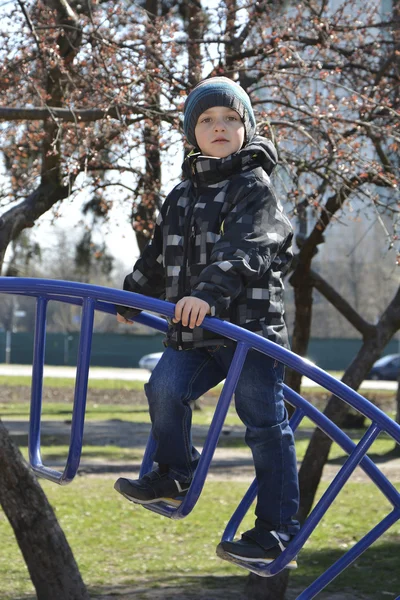 Frühlingsjunge spielt auf dem Spielplatz. — Stockfoto