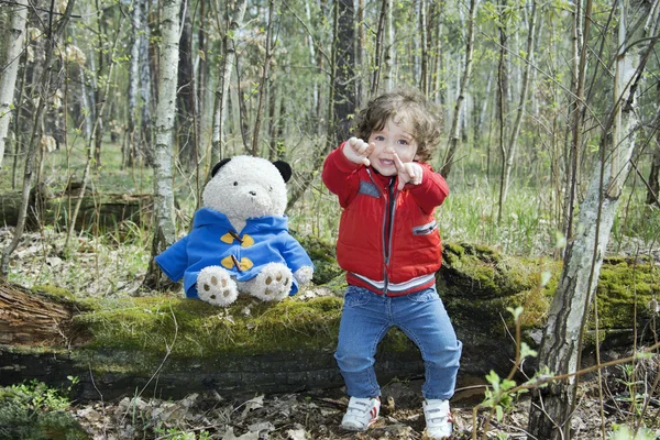 Primavera en el bosque niña jugando con un oso de juguete . — Foto de Stock