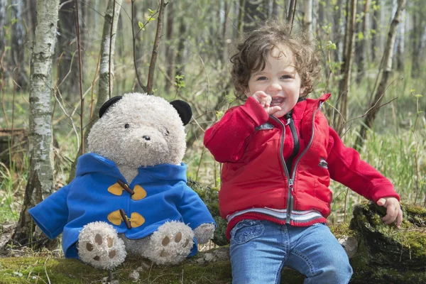 Primavera en el bosque niña jugando con un oso de juguete . —  Fotos de Stock