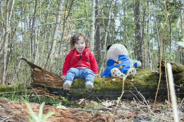 Voorjaar in het forest meisje spelen met een beer speelgoed. — Stockfoto