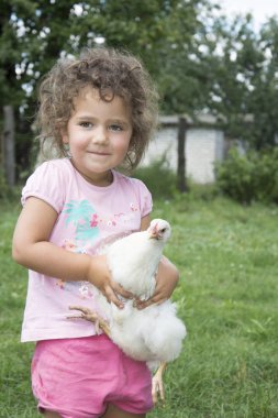 Bir tavuk tutarak Bahçe, yaz aylarında küçük kız.