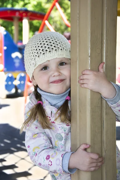 I våras på lekplatsen spelar liten flicka. — Stockfoto